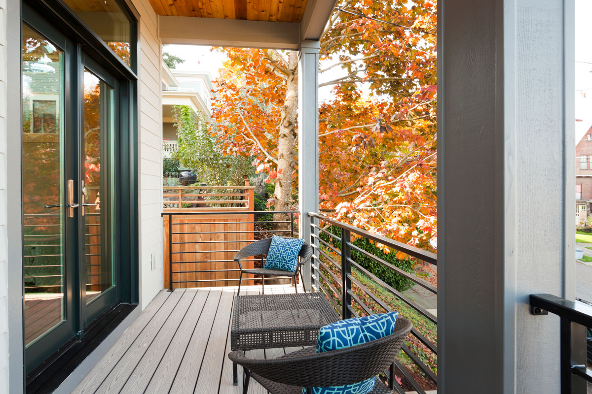 Cozy covered balcony with a french door and a winter season is coming with dried leaves on a tree