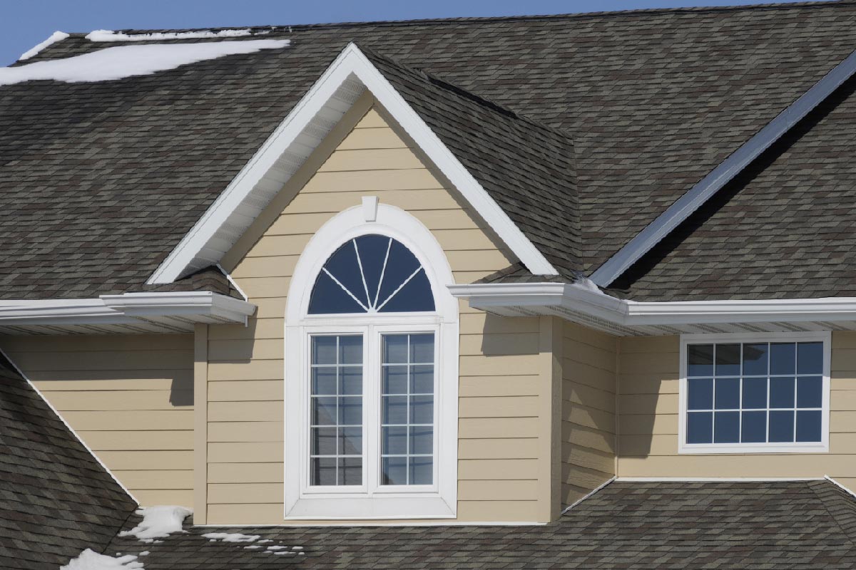 House with asphalt shingle roof and snow