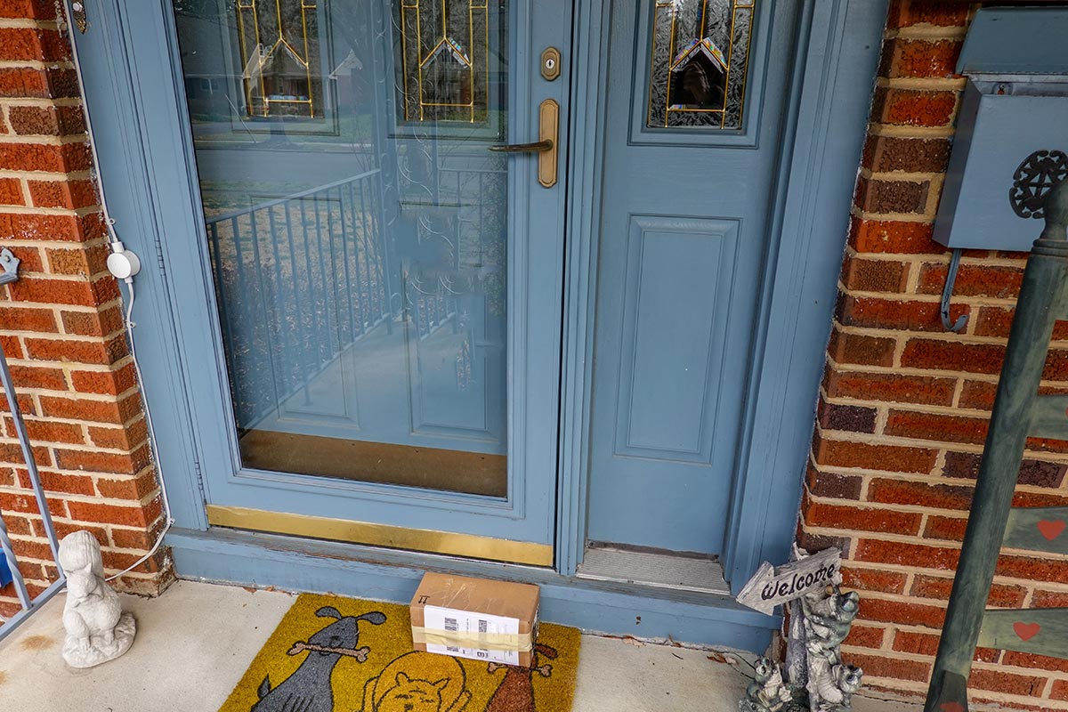 Shipping box on a porch propped up against the front door of a house