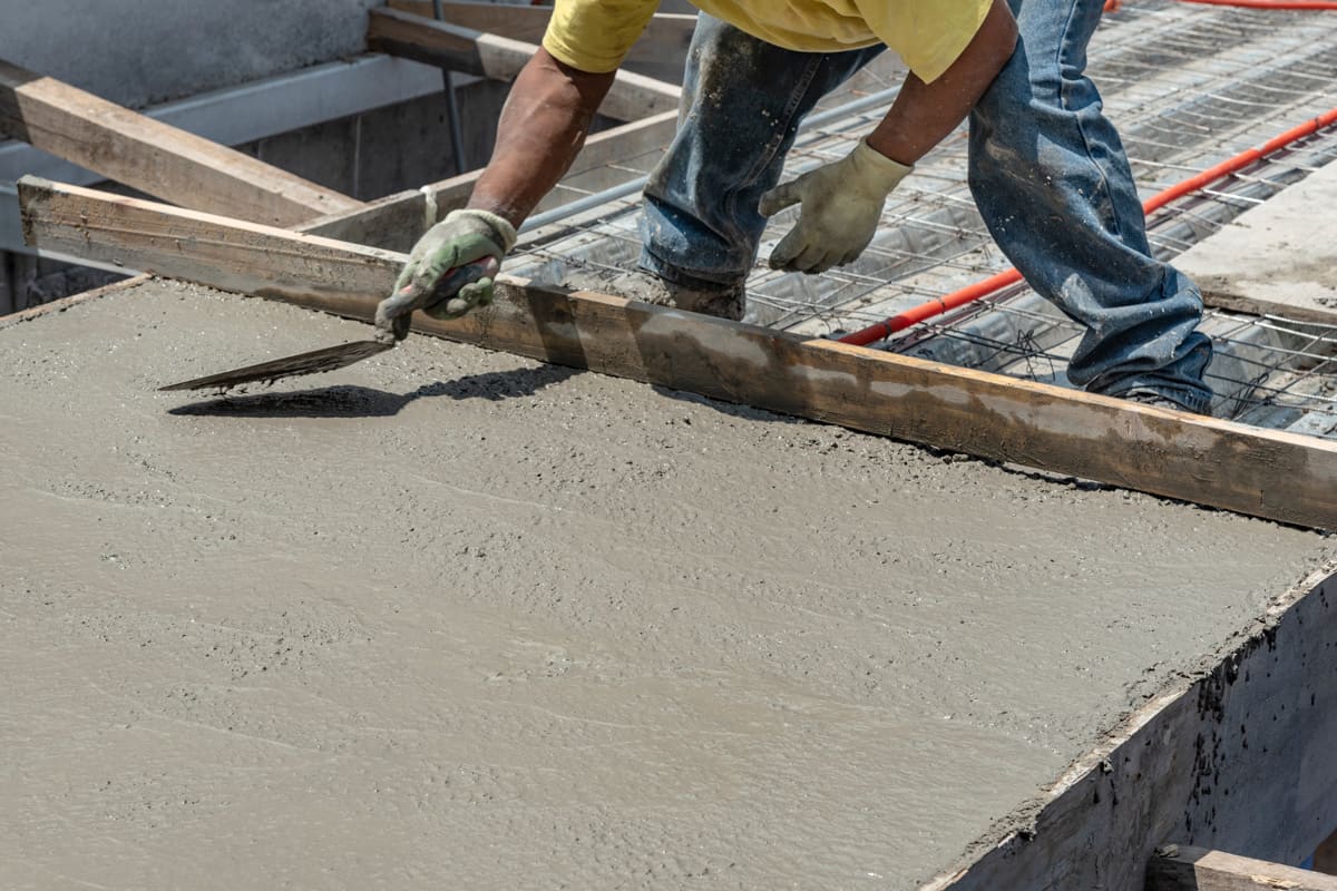 Worker using a trowel to spread cement