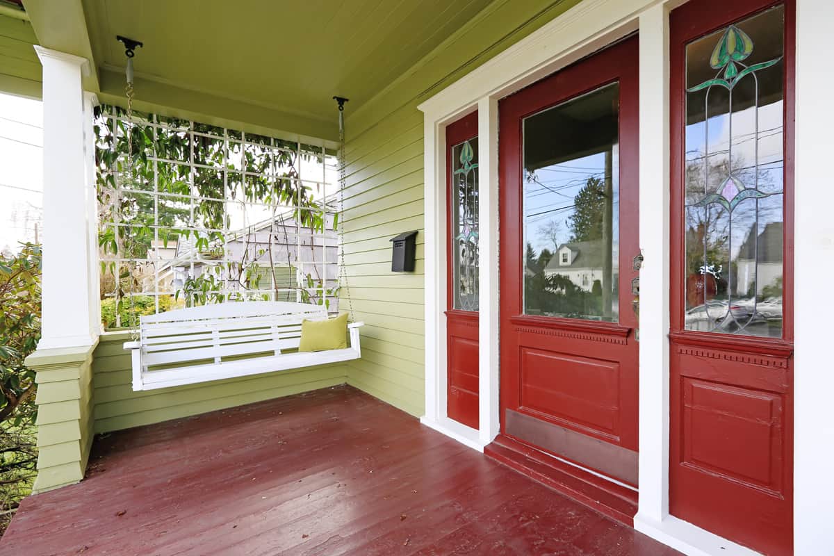 Entrance porch in red and green color with hanging swing