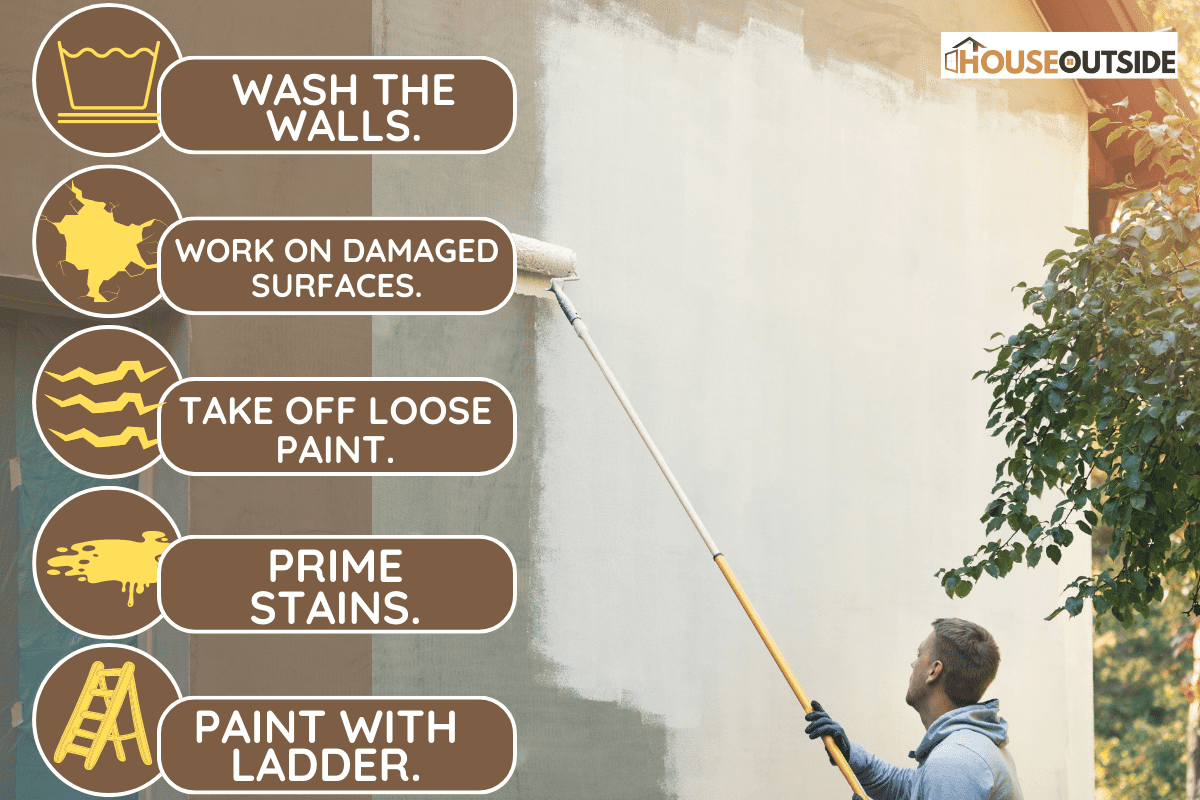 House painter painting building exterior with roller stock photo. - How To Paint Outside Of House Without Scaffolding