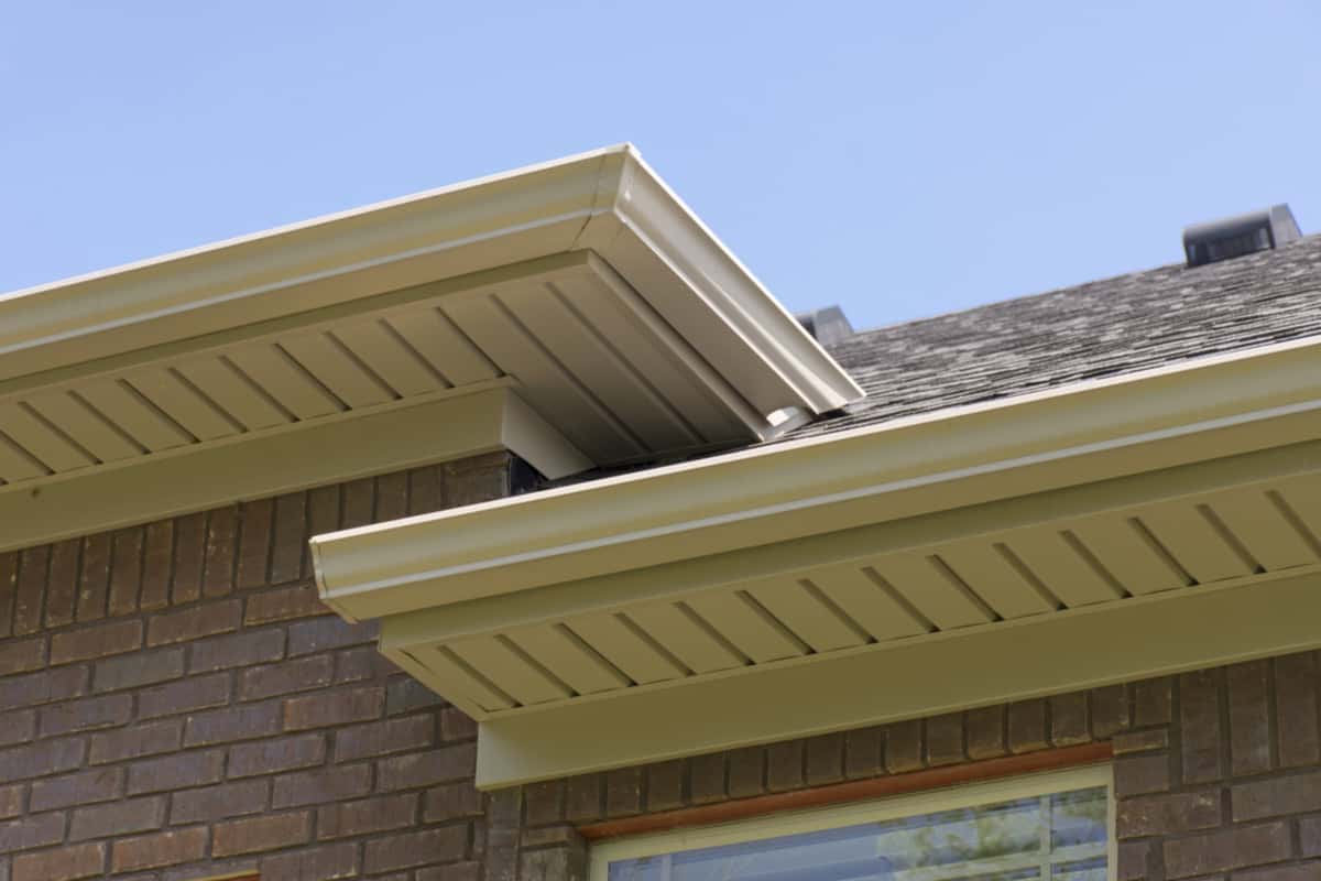 Roof showing gutters and soffit on the back of a brick house. - Soffits