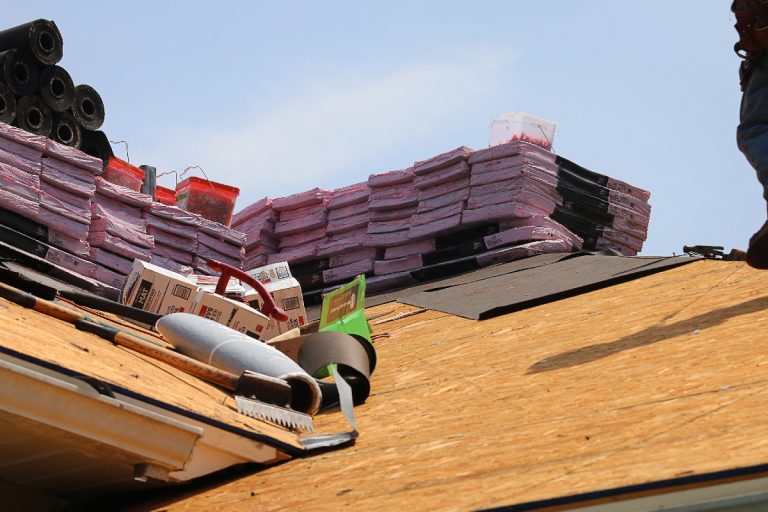 A rooftop loaded with roofing supplies, Does Roof Replacement Include Plywood?