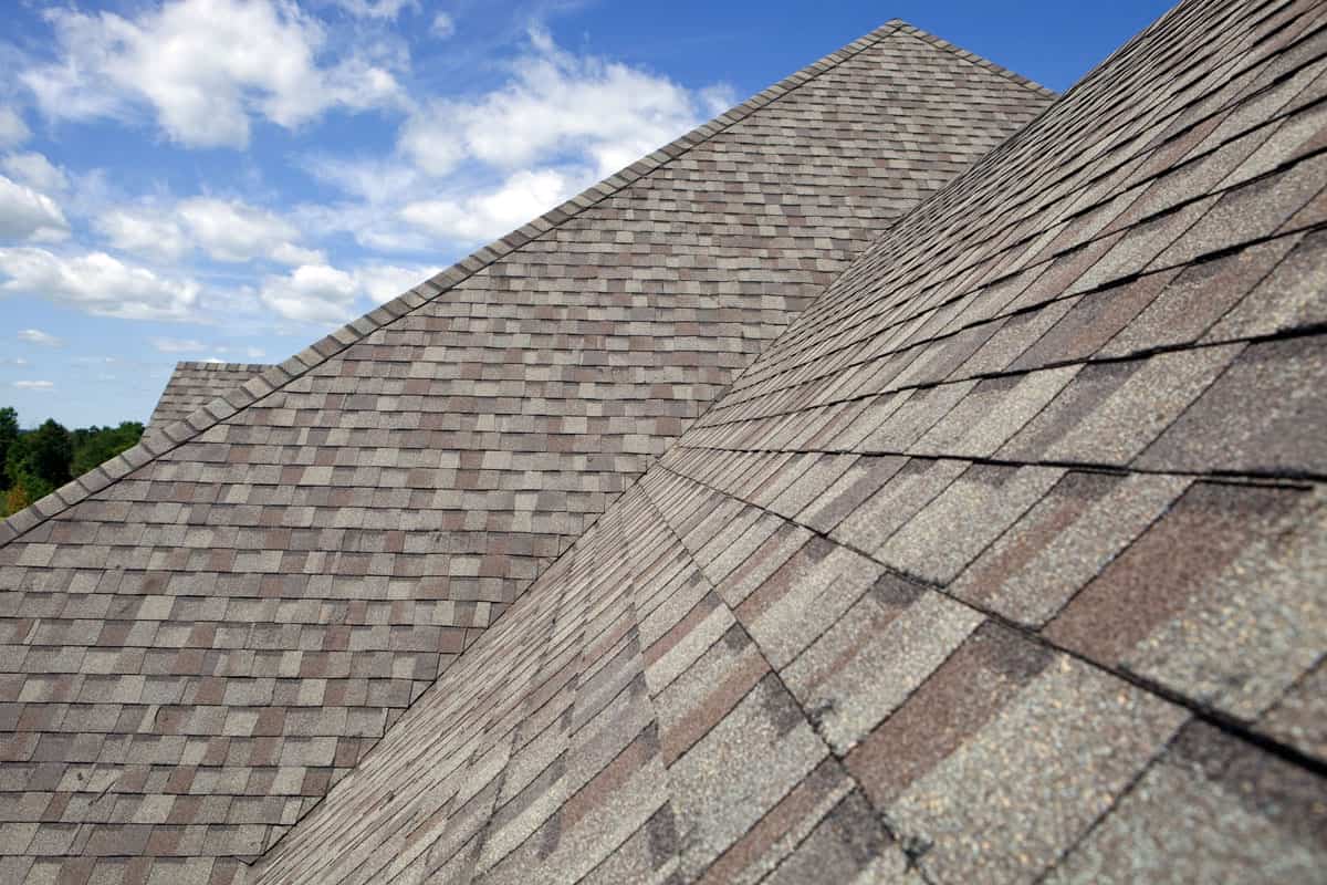 photo of a clear blue sky and a huge big roof valley, brown tone shingles