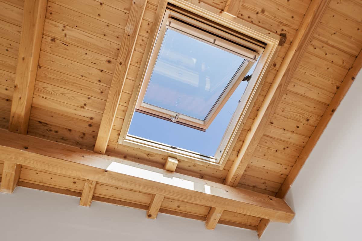 photo of a wooden sky light window on the bedroom on the attic of the house