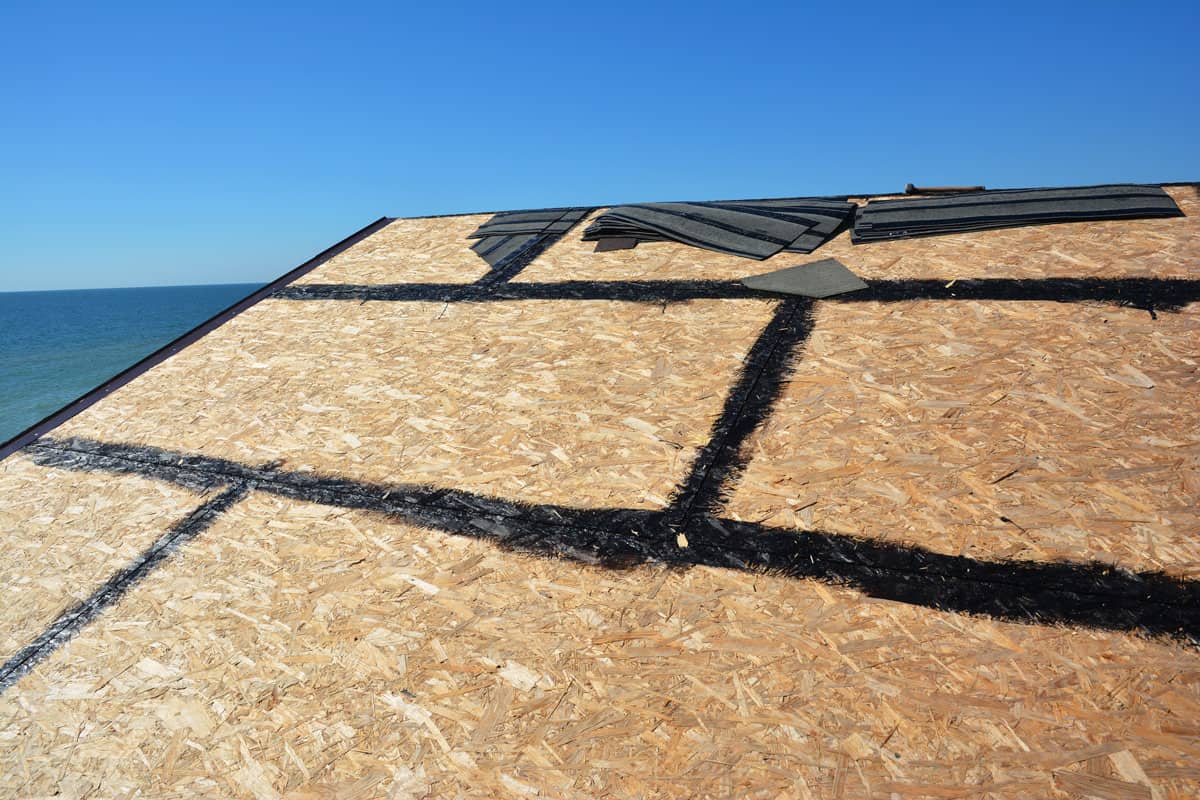 up close photo of a sunny day on top of the house roof sheathing installation. Sunny weather