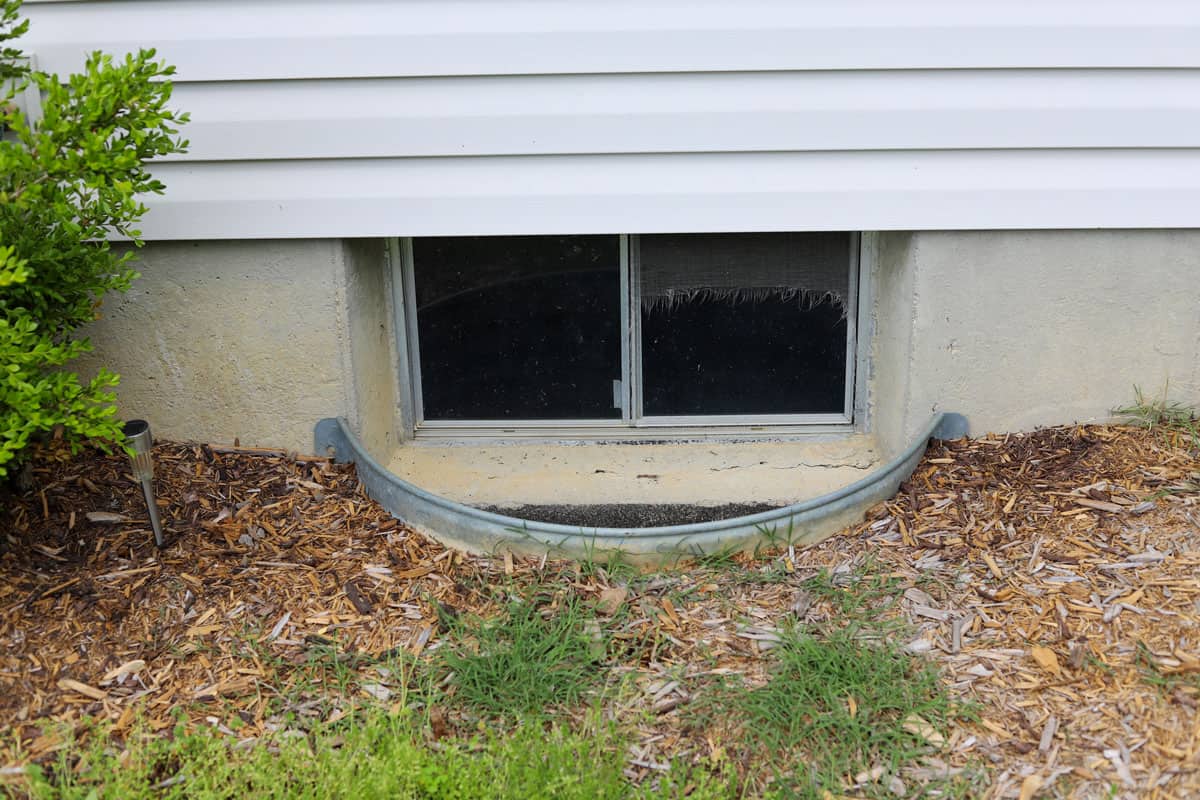 A view of a basement window well of a residential home