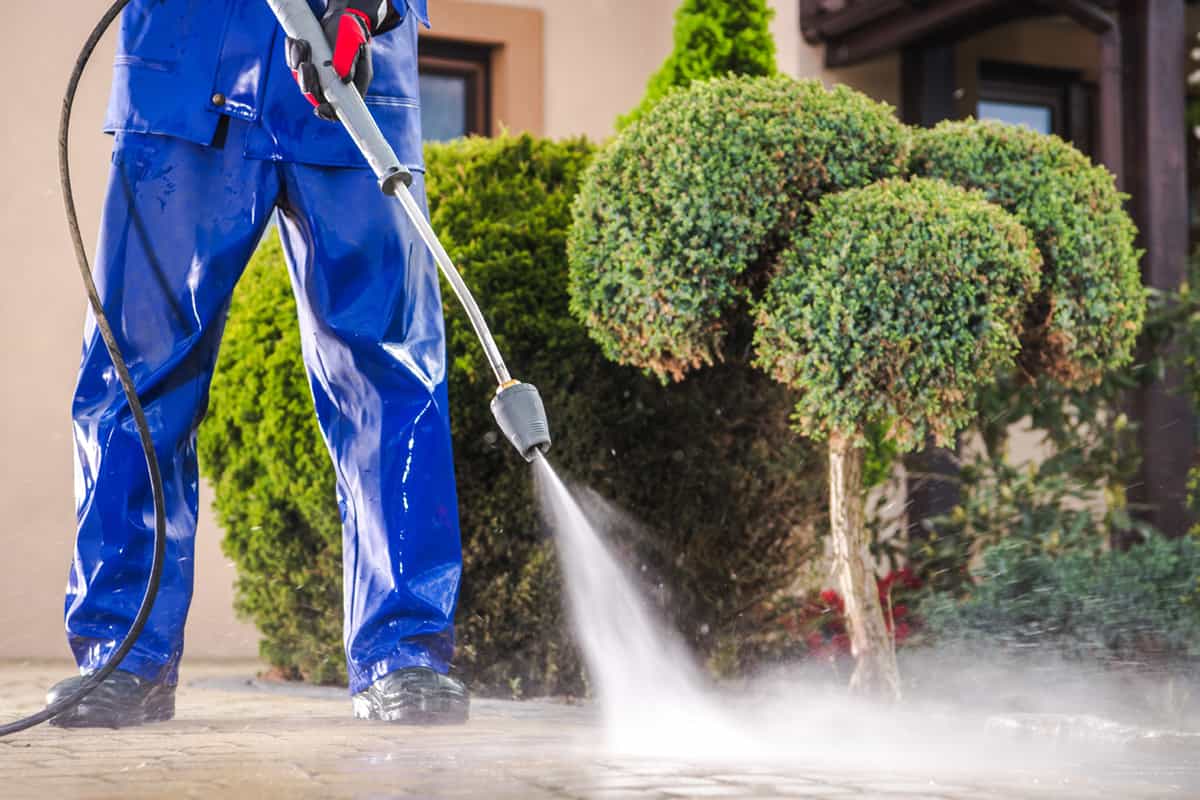 Cleaning residential driveway with pressure washer