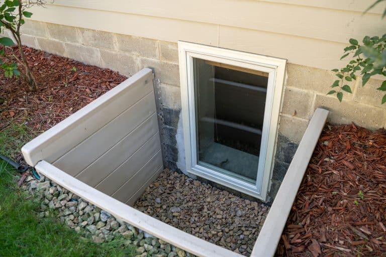 Exterior view of an egress window in a basement bedroom., Do Basement Windows Have To Open?