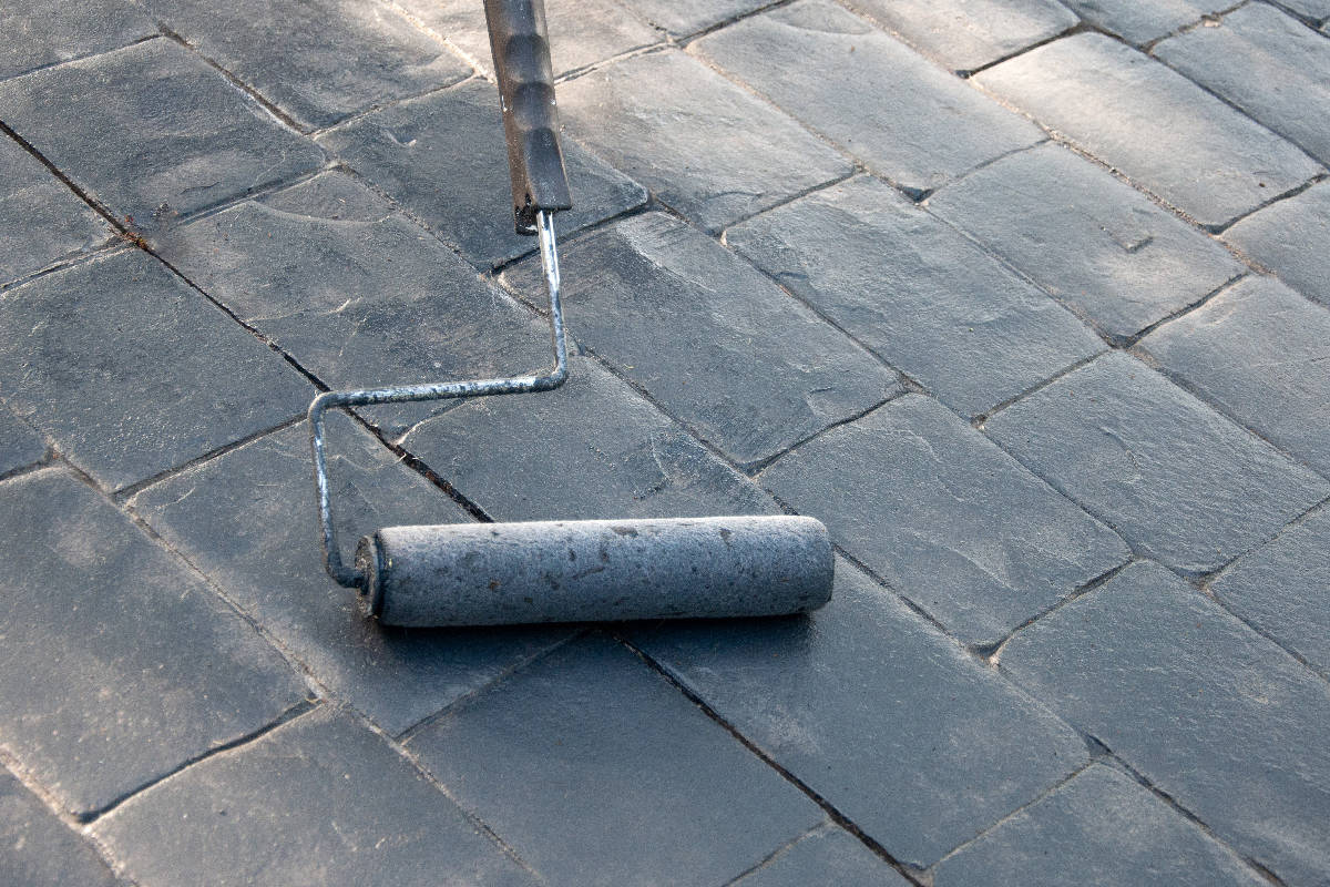 Sealing and painting bricks driveway with a roller tool