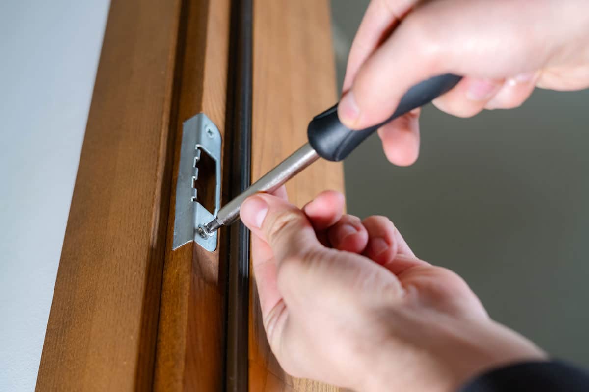 carpenter-repairing-door-lock-installing-handle