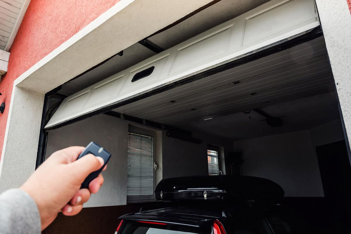 garage-door-pvc-hand-use-remote red painted wall black car inside