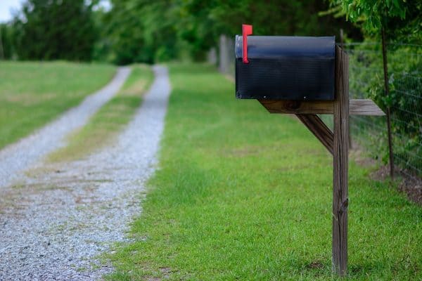 A large black metal mailbox along a quiet country road, How To Stabilize A Mailbox Post Without Concrete
