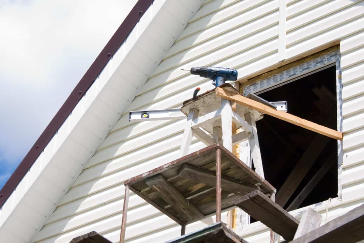 Installation of a siding on a house against the sky
