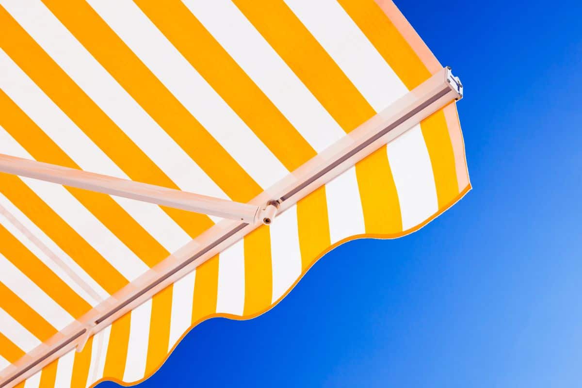 Yellow-white stripped awning against blue summer sky. Canon 5D Mk II.