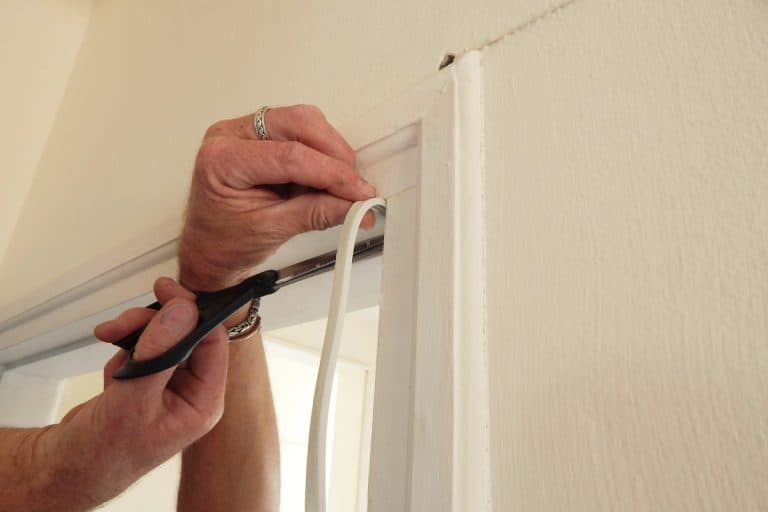 hands affixing adhesive rubber draft proofing to a door frame., What Glue Do You Use For Weather Stripping Door?