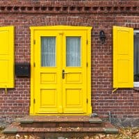 A beautiful yellow front door with matching yellow shutters, What Color Front Door With Yellow Siding?