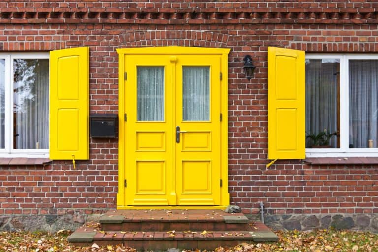 A beautiful yellow front door with matching yellow shutters, What Color Front Door With Yellow Siding?