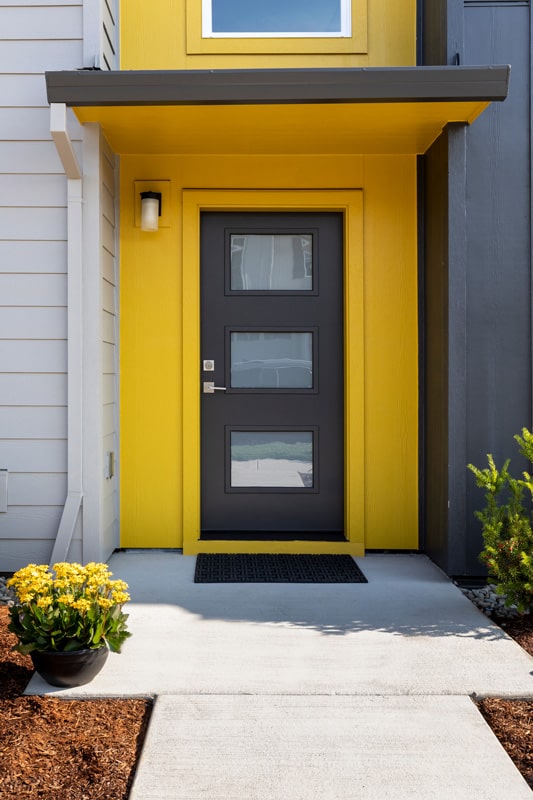 A-modern-house-with-a-gray-door-and-yellow-framing